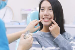 smiling woman pointing at her teeth